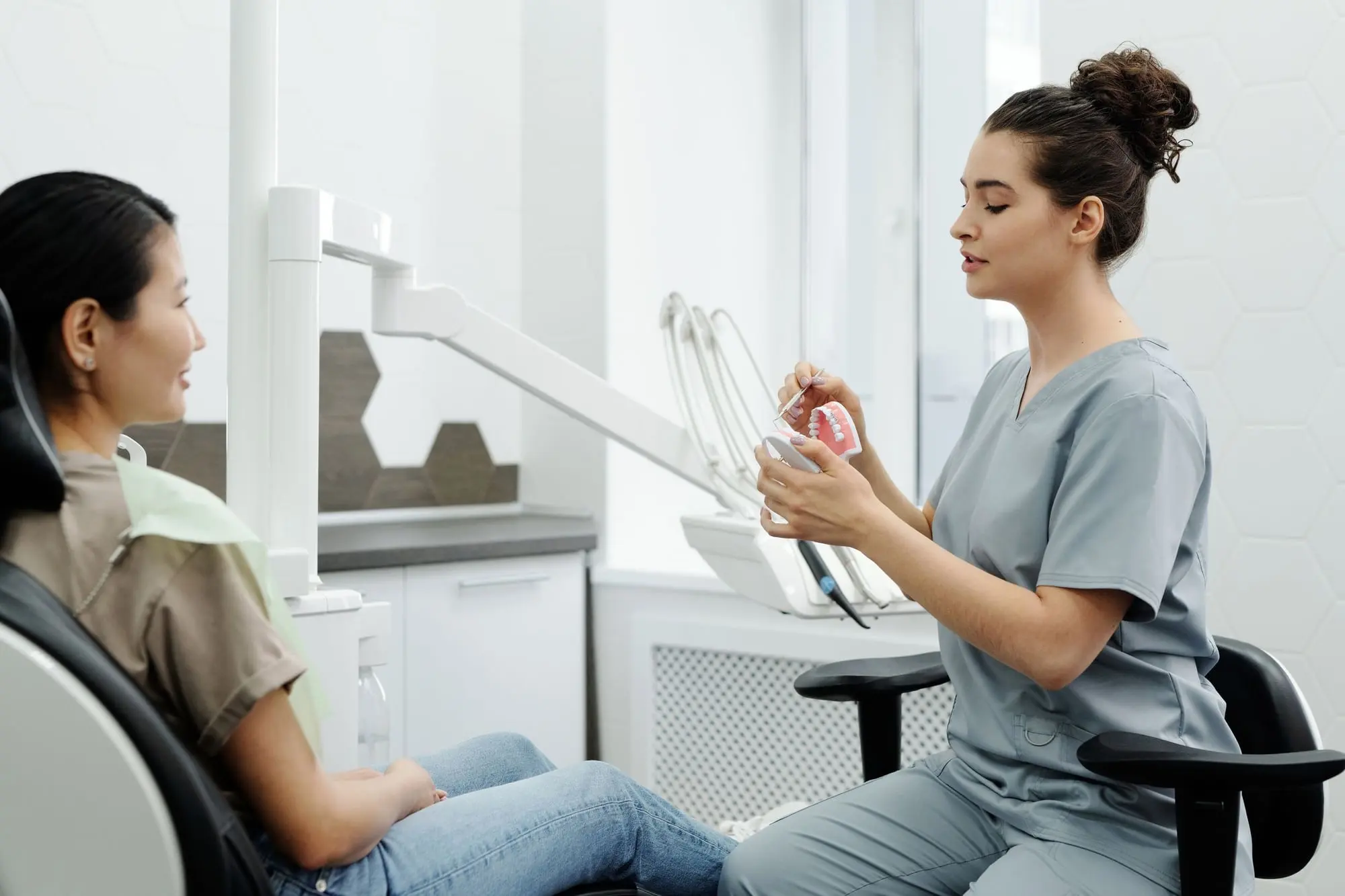 Dentist chatting with a relaxed patient in a bright, modern surgery