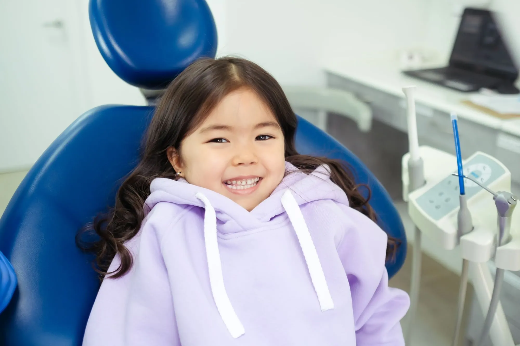 Happy young girl smiling in the dental chair